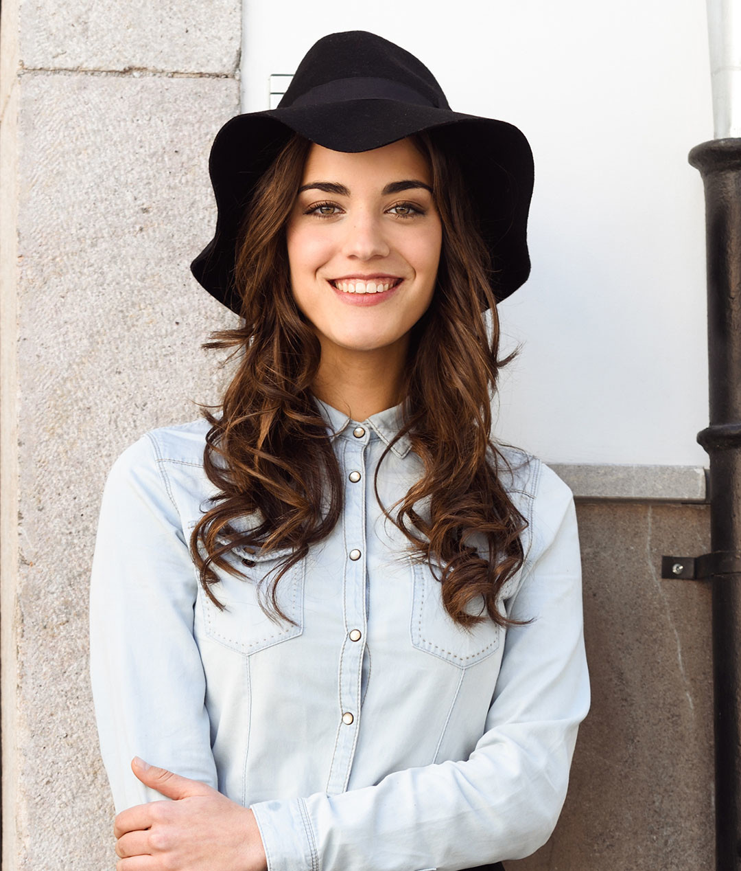 Portrait of young woman in urban background wearing casual clothes and hat